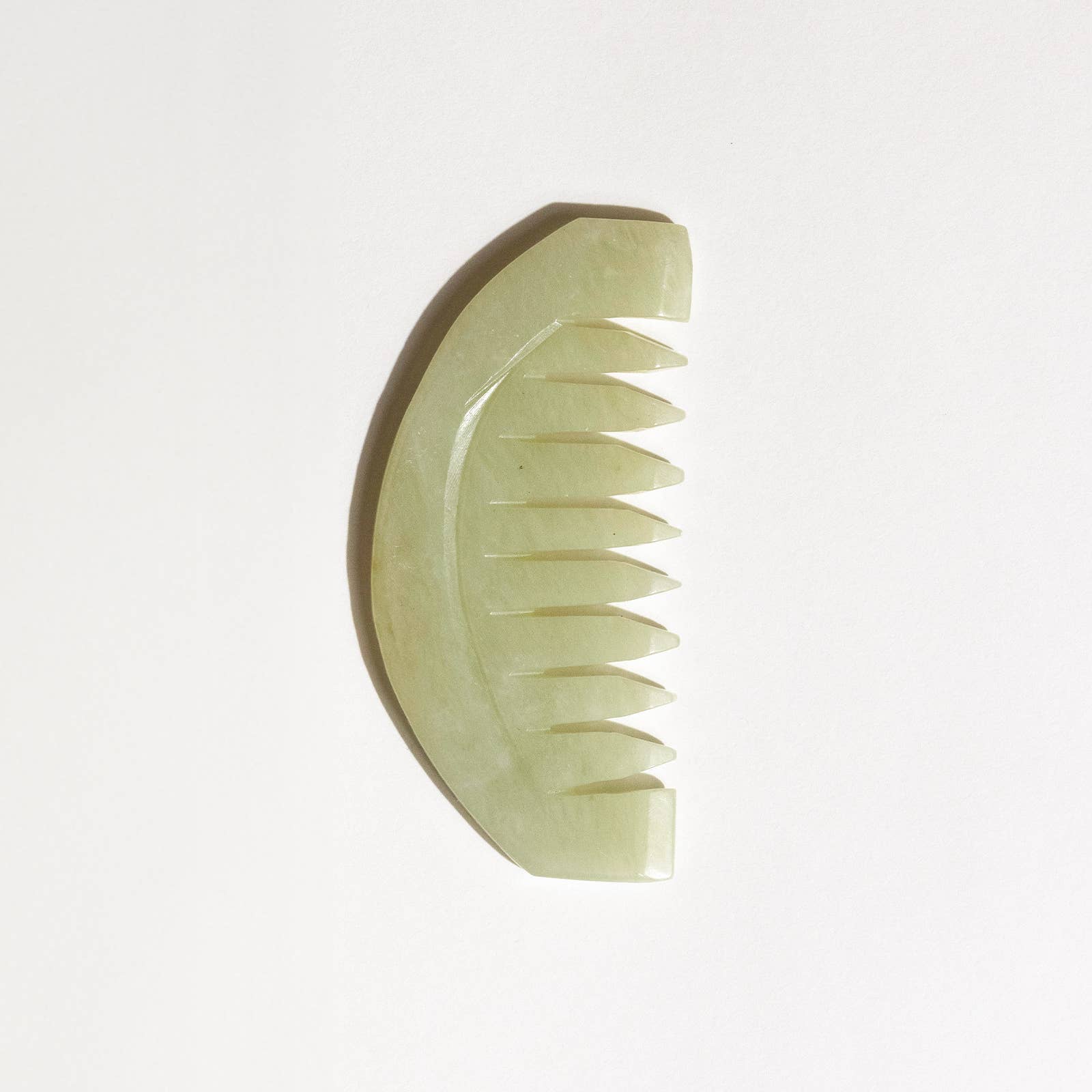 Green jade comb on a white background