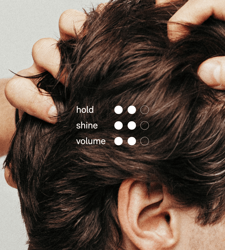 Close-up of a person using hair putty in their hair with text &