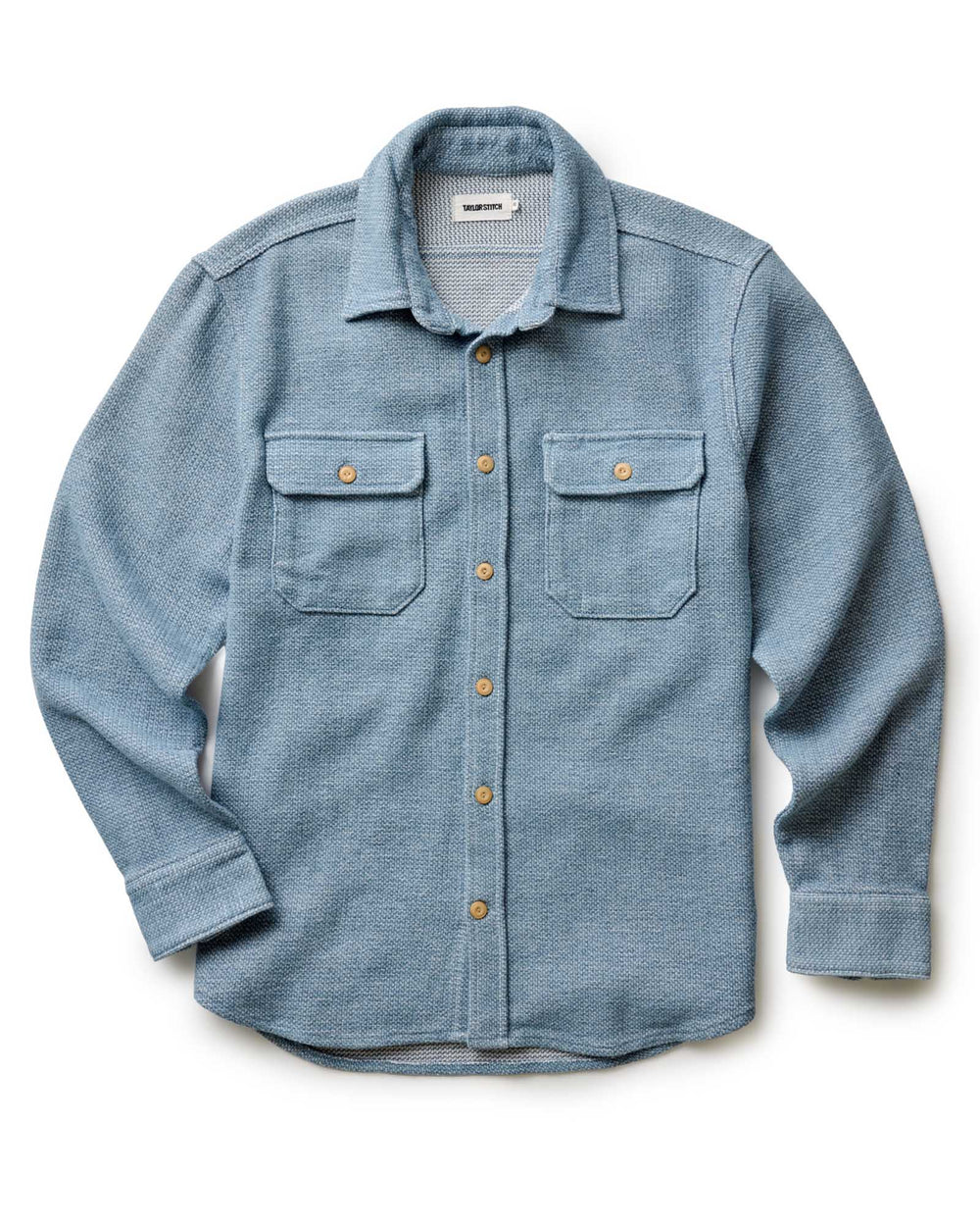 Blue flannel shirt with button details on a white background