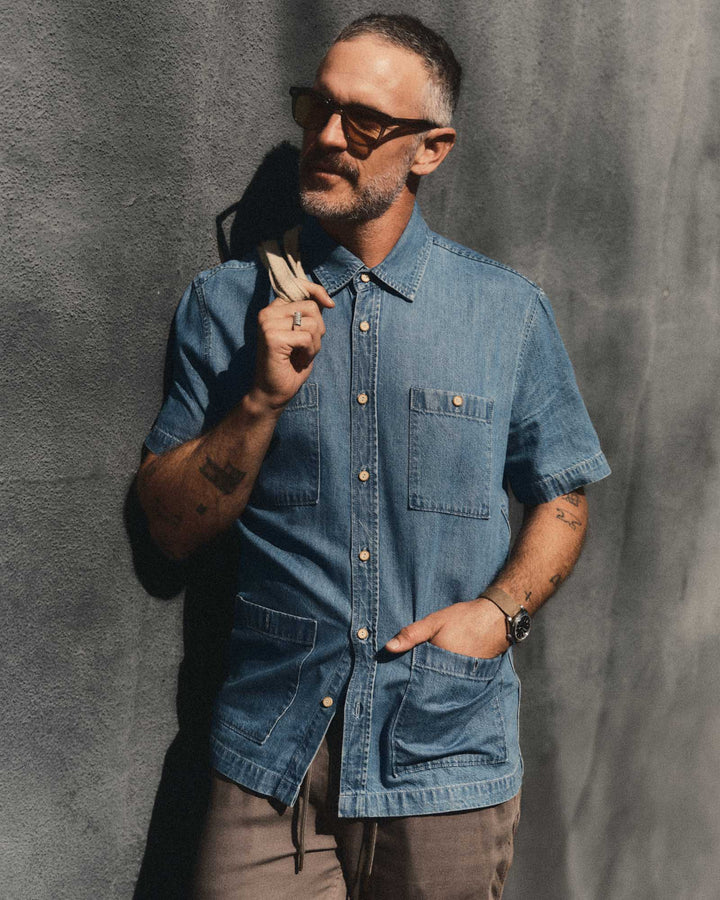Man wearing The Gulf Shirt in Washed Indigo Twill against a gray background