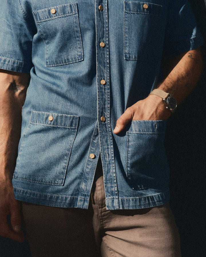 Close-up of a person wearing The Gulf Shirt in Washed Indigo Twill with visible buttons and pockets.