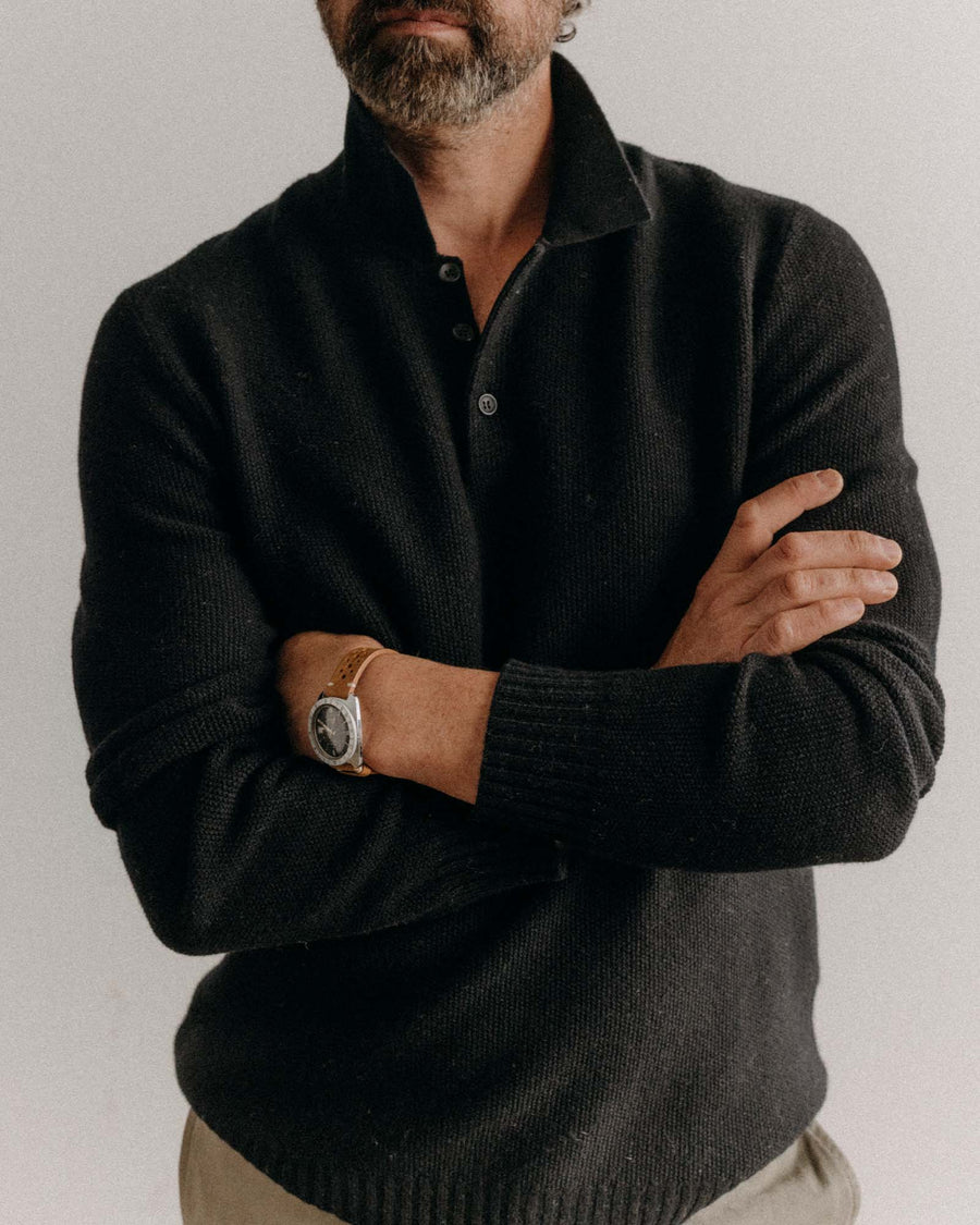Man wearing a Midnight sweater with arms crossed against a plain background
