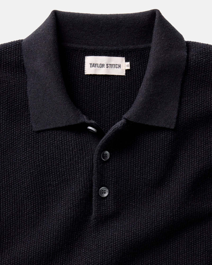 Midnight polo shirt with 'Taylor Stitch' label on a light gray background
