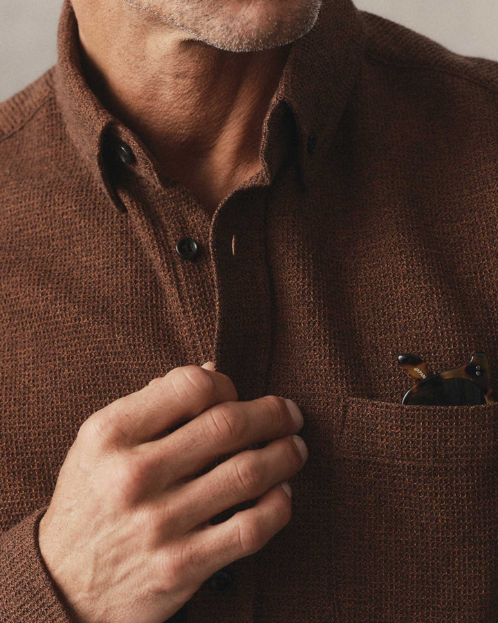 Close-up of a man wearing The Jack Shirt in Timber Twist Waffle, adjusting the collar with one hand while resting the other on a chest pocket.