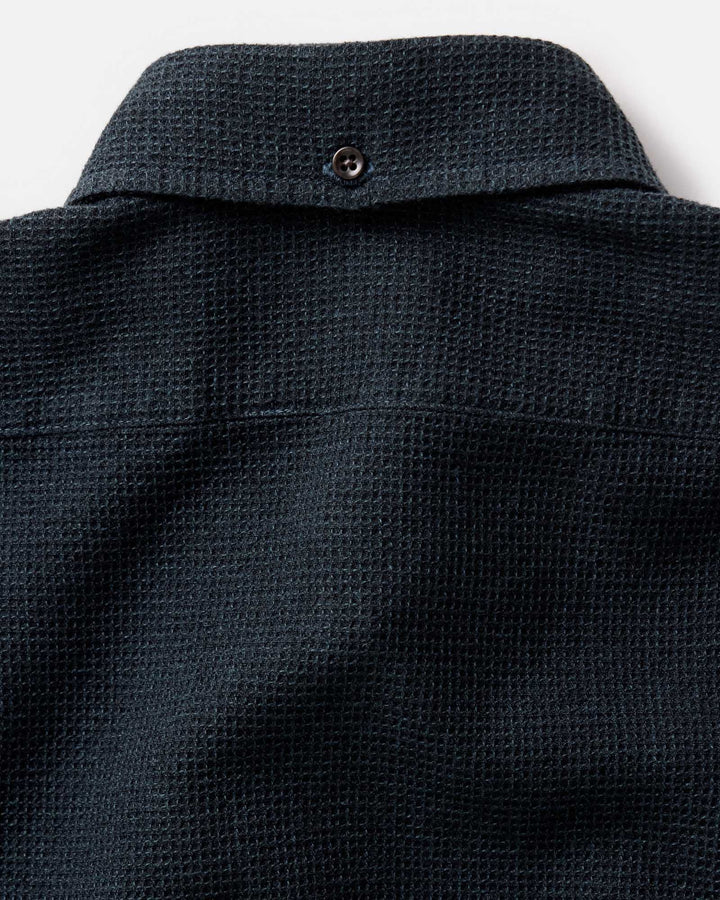Close-up of the back collar of The Jack Shirt in Forest Waffle, showing a small button closure and the fabric weave against a light background.