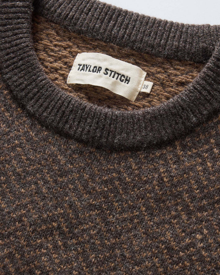 Close-up of a brown sweater with 'Taylor Stitch' label