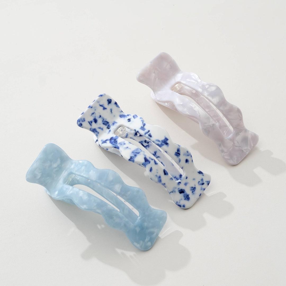 Three Adorro hair clips in Coastal blue, Saltwater Blue, and Ivory on a light background