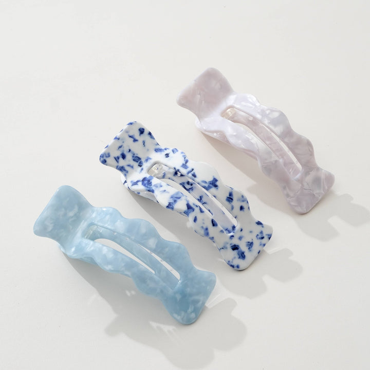 Three Adorro hair clips in Coastal blue, Saltwater Blue, and Ivory on a light background