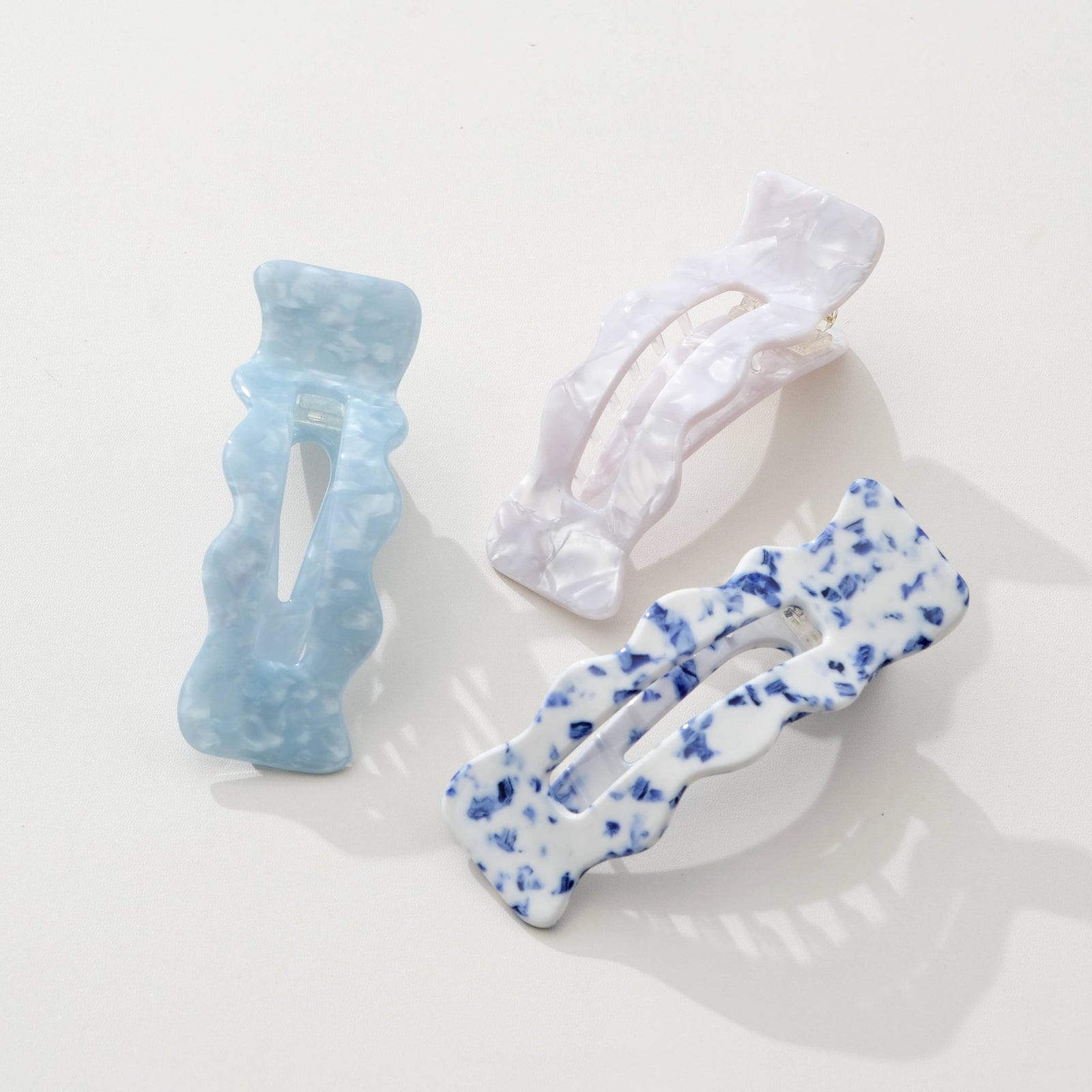 Three Adorro hair clips in Coastal blue, Saltwater Blue, and Ivory on a light background