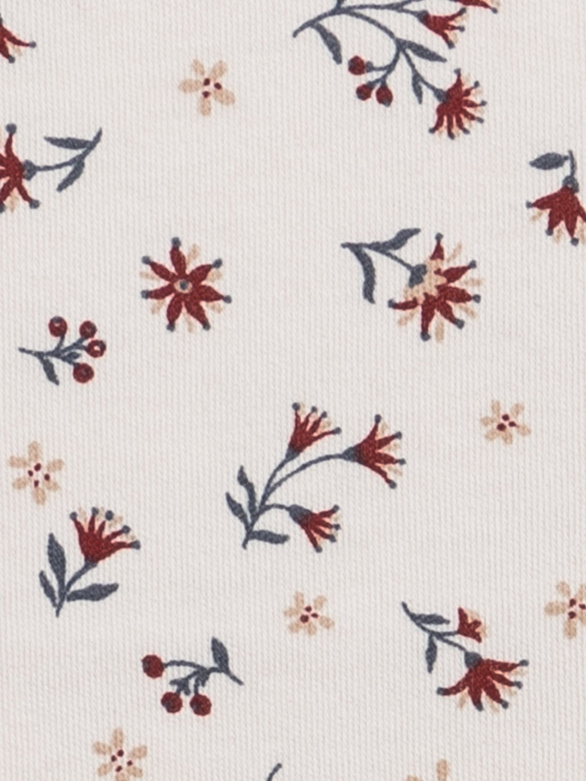 A close-up of a cream-colored fabric with a delicate floral pattern featuring dark blue-gray stems and leaves, burgundy-red flowers, and small beige blossoms.