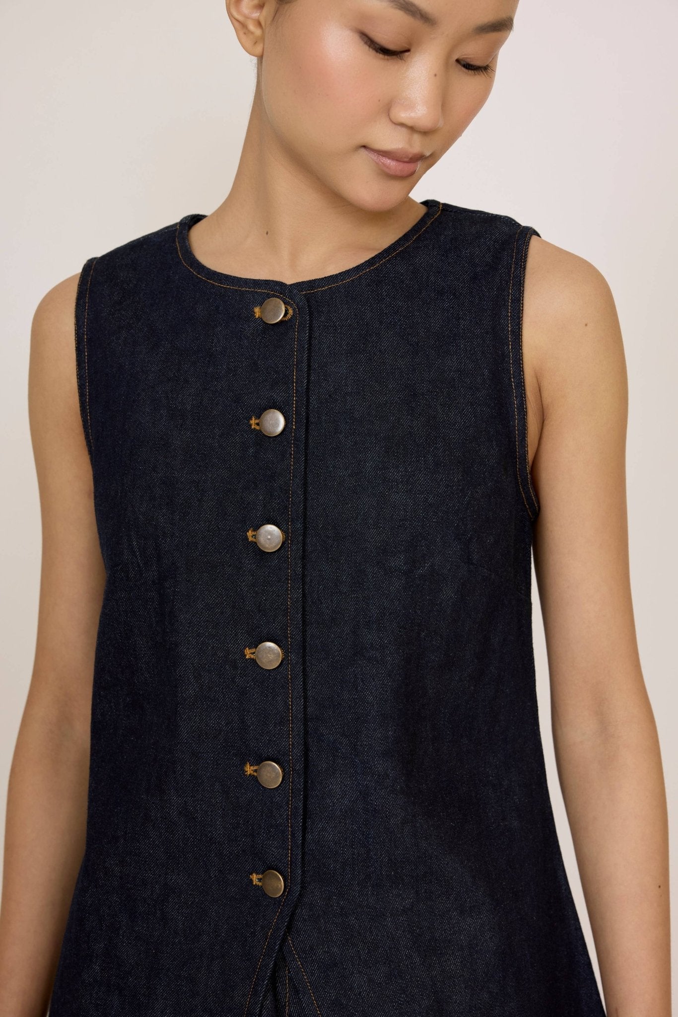 Woman wearing a Laude Longline Vest in Dark Indigo over a plain background