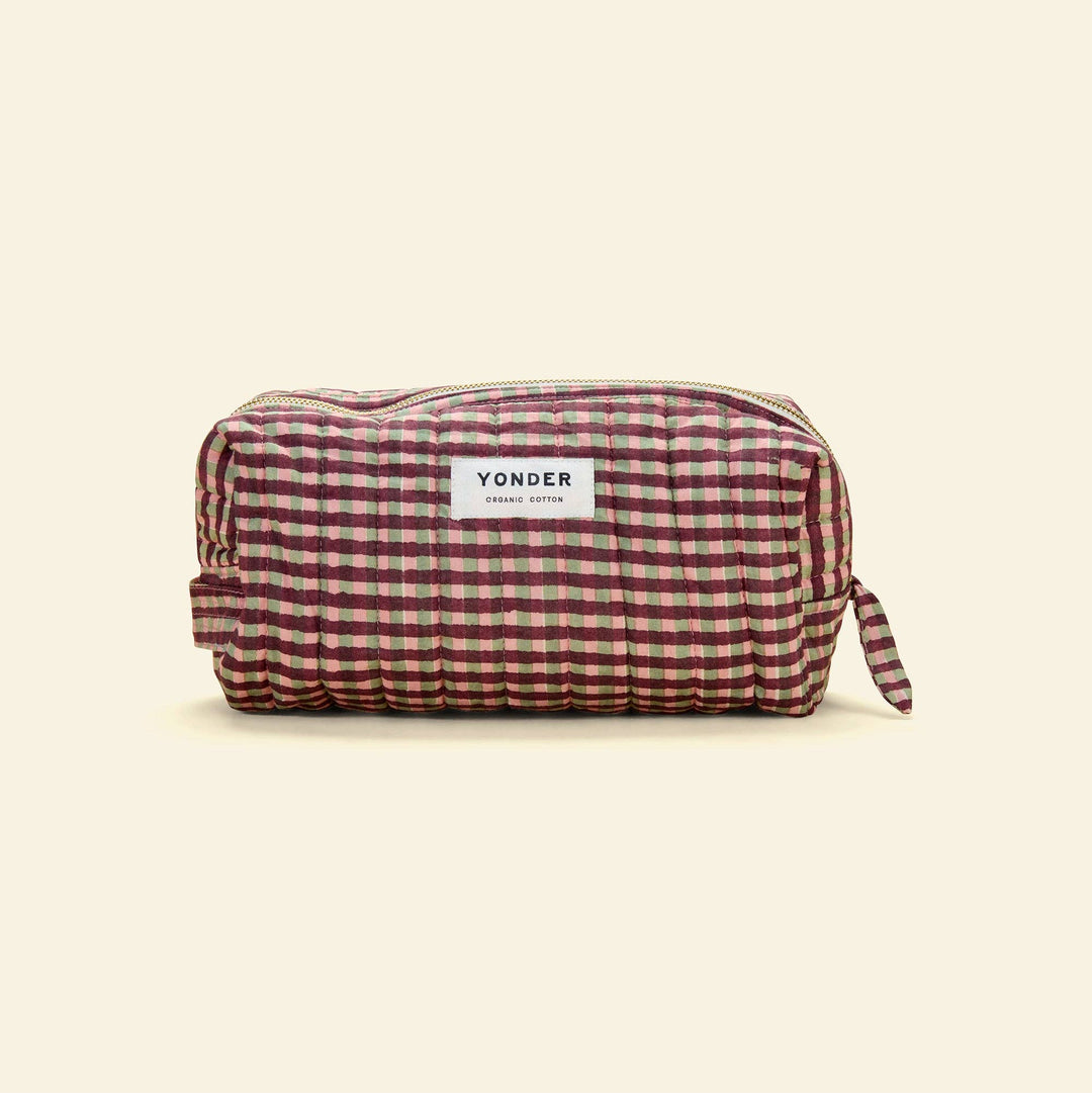 A Yonder zippered pouch in a red and green gingham pattern, shown on a solid cream background.