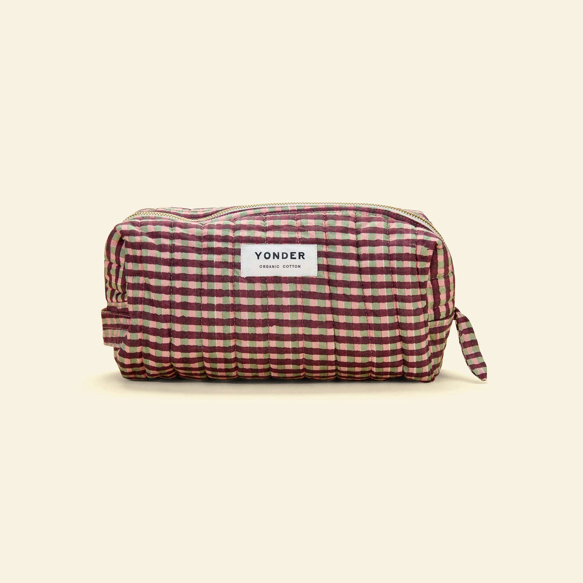 A Yonder zippered pouch in a red and green gingham pattern, shown on a solid cream background.