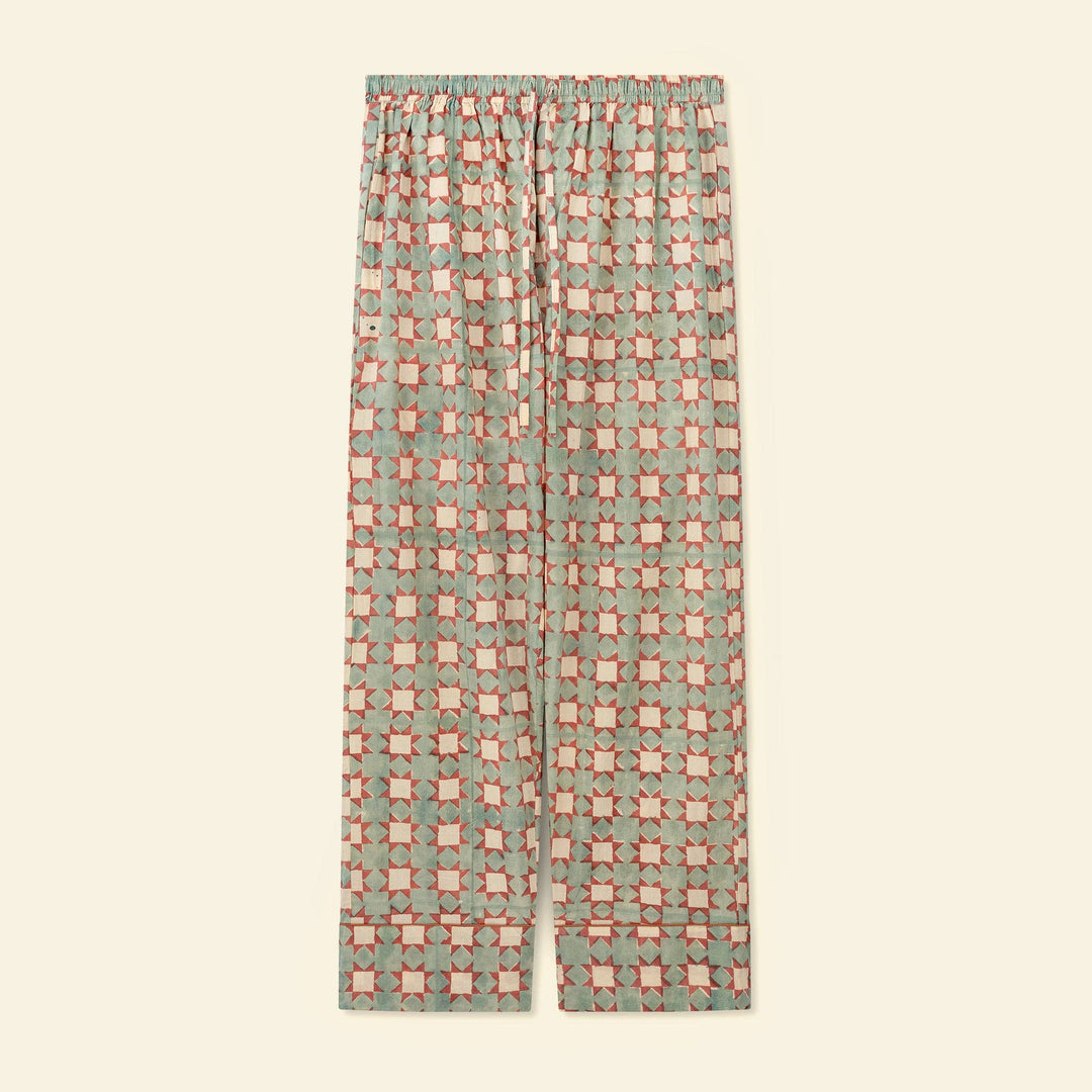 A pair of pajama pants featuring an all-over geometric checkered pattern, displayed flat against a solid cream background.