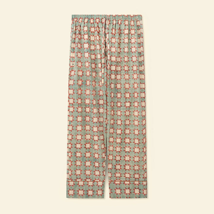 A pair of pajama pants featuring an all-over geometric checkered pattern, displayed flat against a solid cream background.