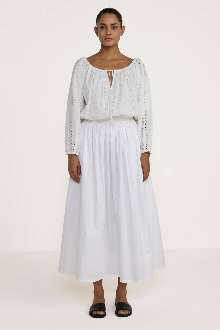 Woman wearing a Laude the Label Off The Shoulder Blouse in Ivory Lace with intricate detailing on a plain background