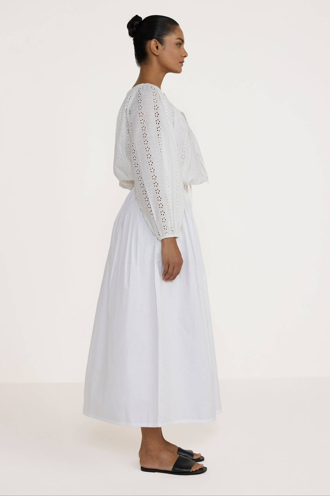 Woman wearing a Laude the Label Off The Shoulder Blouse in Ivory Lace with intricate detailing on a plain background