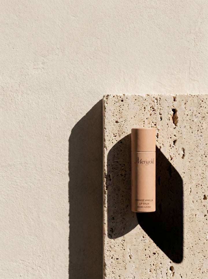 Lip balm on a textured stone surface with a neutral background