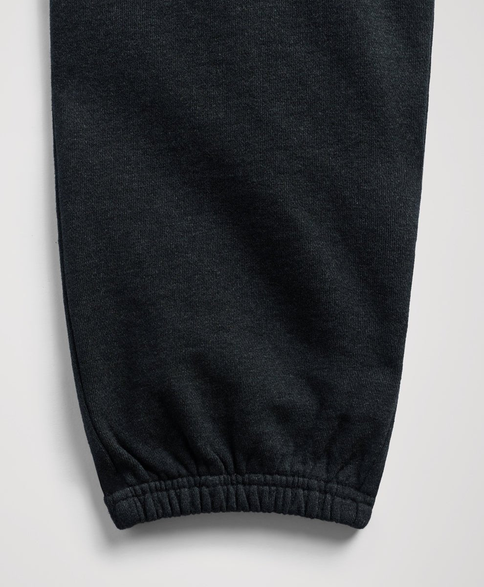 Close-up of a charcoal heather fabric garment, showing a ribbed elastic cuff on a light gray background.
