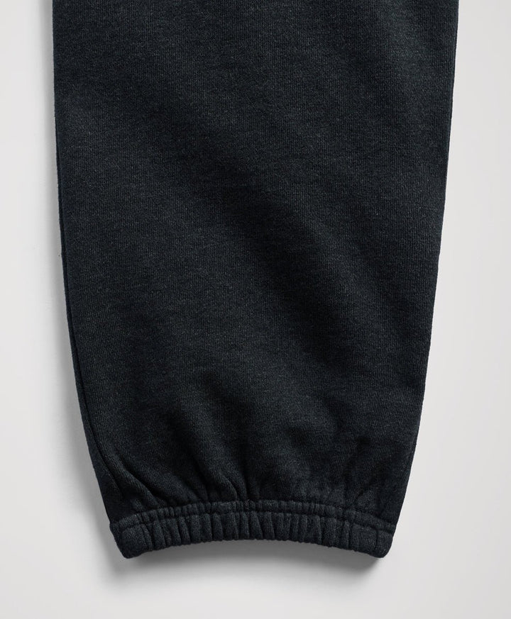 Close-up of a charcoal heather fabric garment, showing a ribbed elastic cuff on a light gray background.