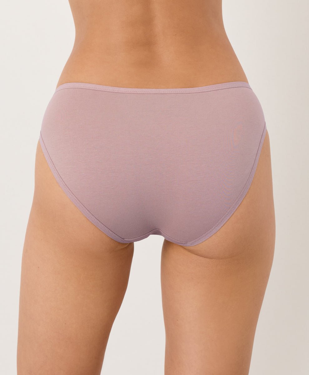 Person wearing a pair of light purple underwear on a plain background