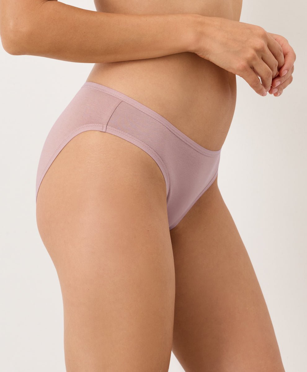 Person wearing a light pink underwear on a plain background
