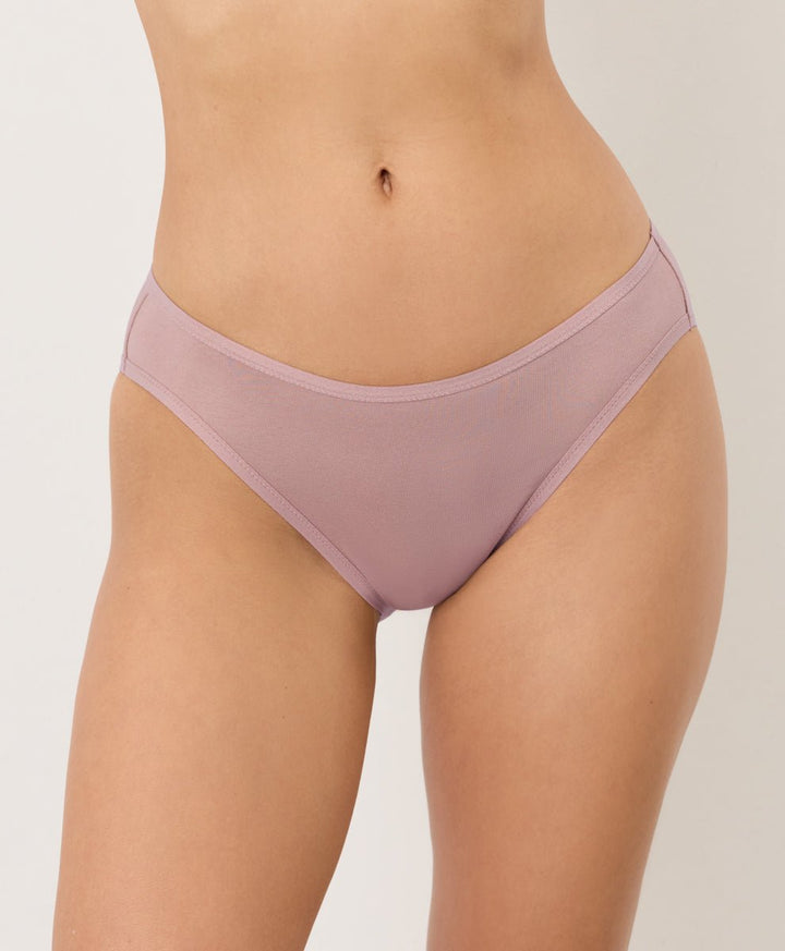 Person wearing a pair of pink underwear on a plain background