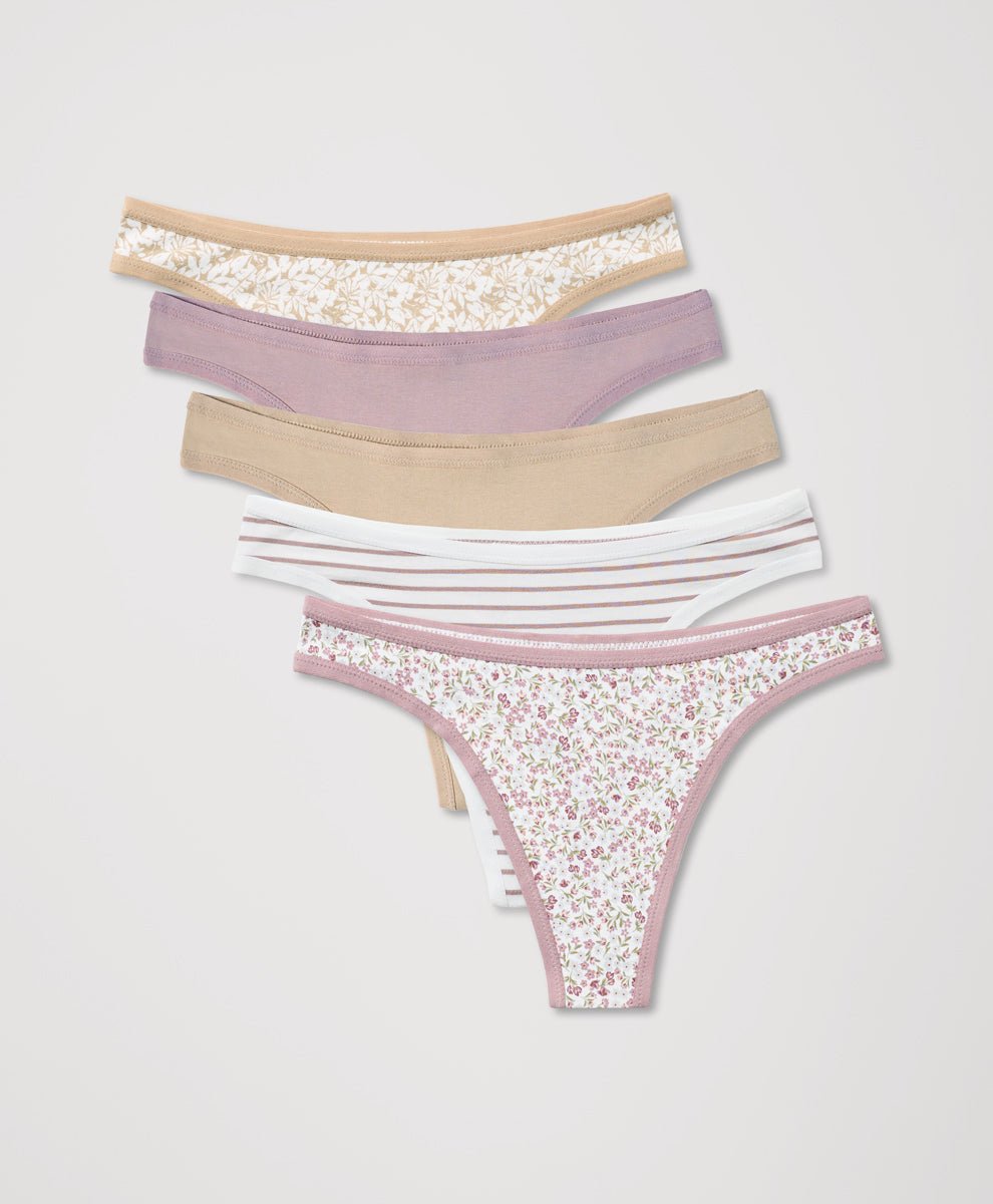 Set of women's thongs with floral, solid and striped patterns on a light gray background