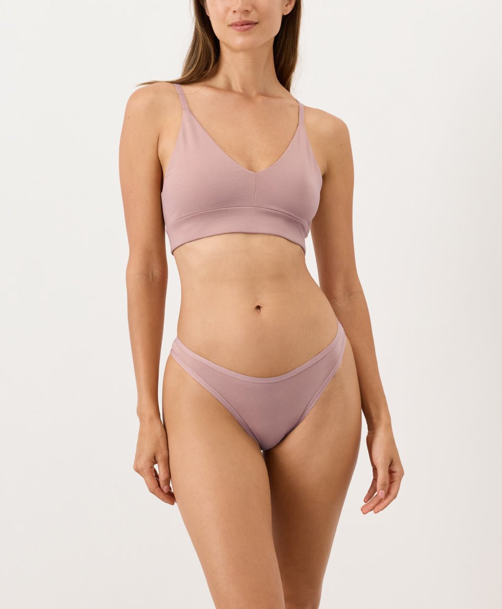 Woman wearing a mauve thong set on a white background