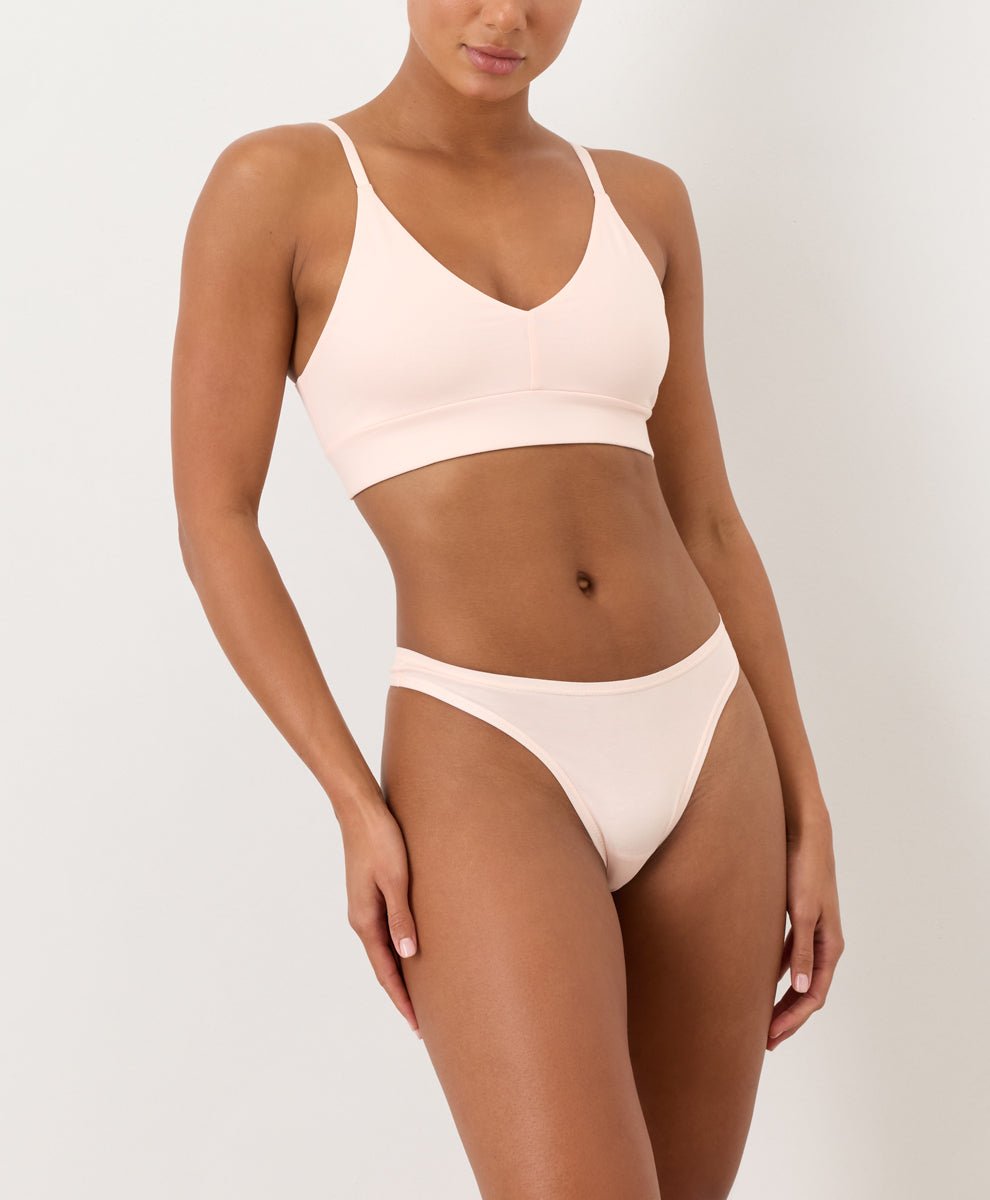 Light Pink thong and T-Shirt Bra worn by a person on a plain background