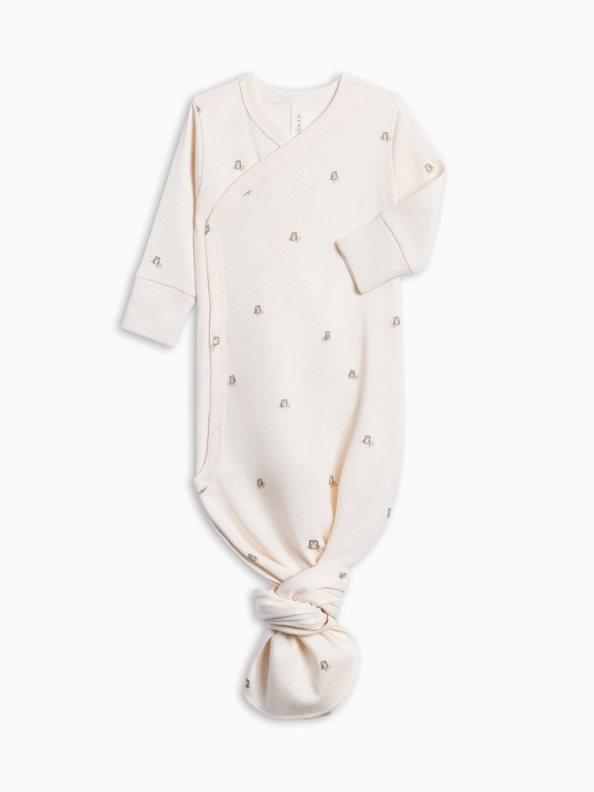 A cream-colored long-sleeve baby sleep sack with small metallic owl embroidered motifs, featuring a wrap-around front and a knotted tie at the bottom, shown on a plain white background.