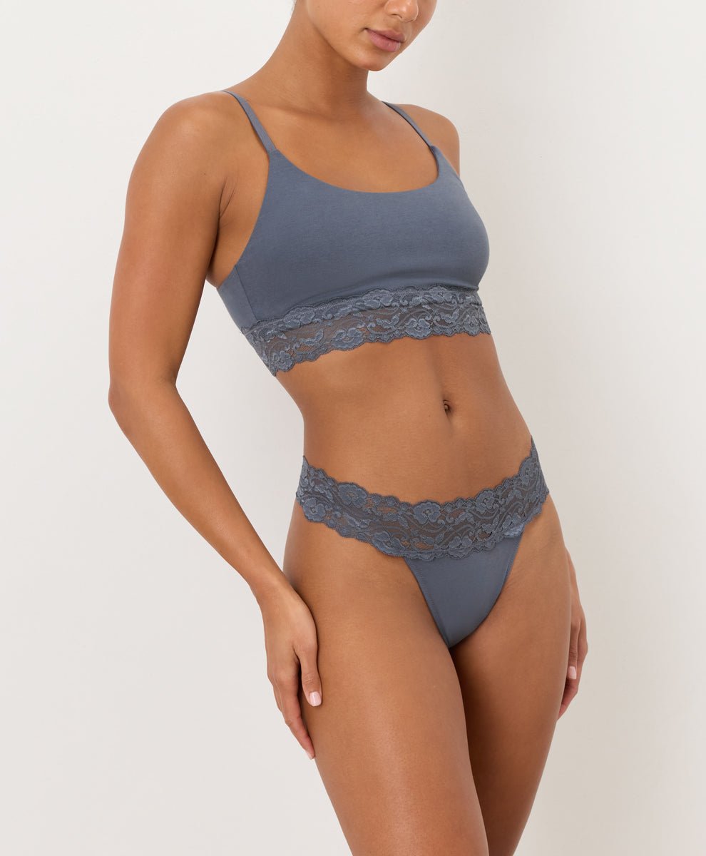Person wearing a Blue lace thong and bra on a plain background