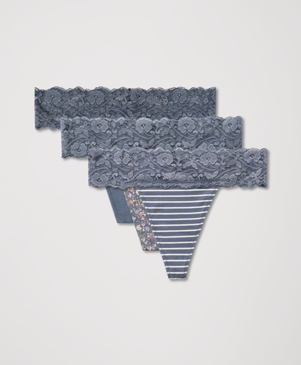 Set of lace-trimmed thongs with striped, solid, and floral designs on a light gray background