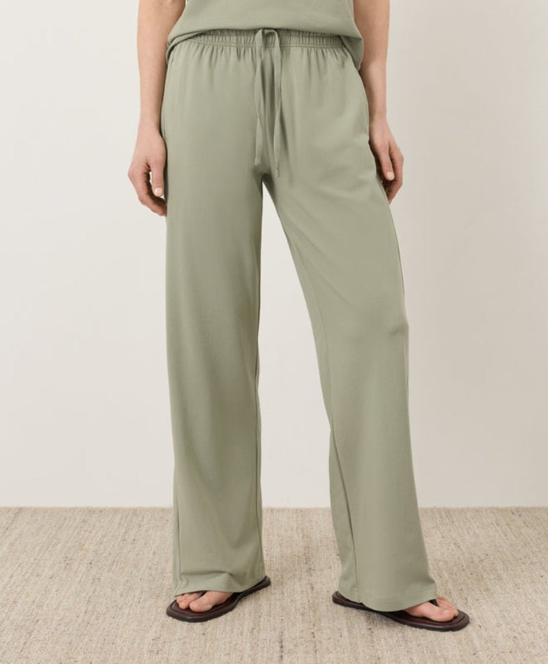 Person wearing light green pants on a plain background