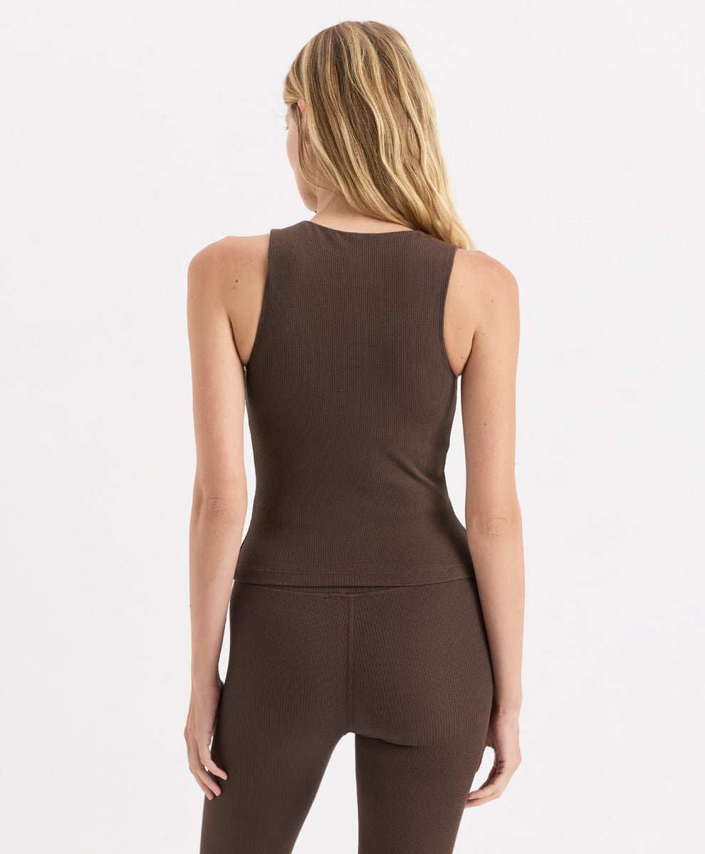 A woman shown from the back wearing a cocoa ribbed sleeveless tank top and matching leggings against a light gray studio background.