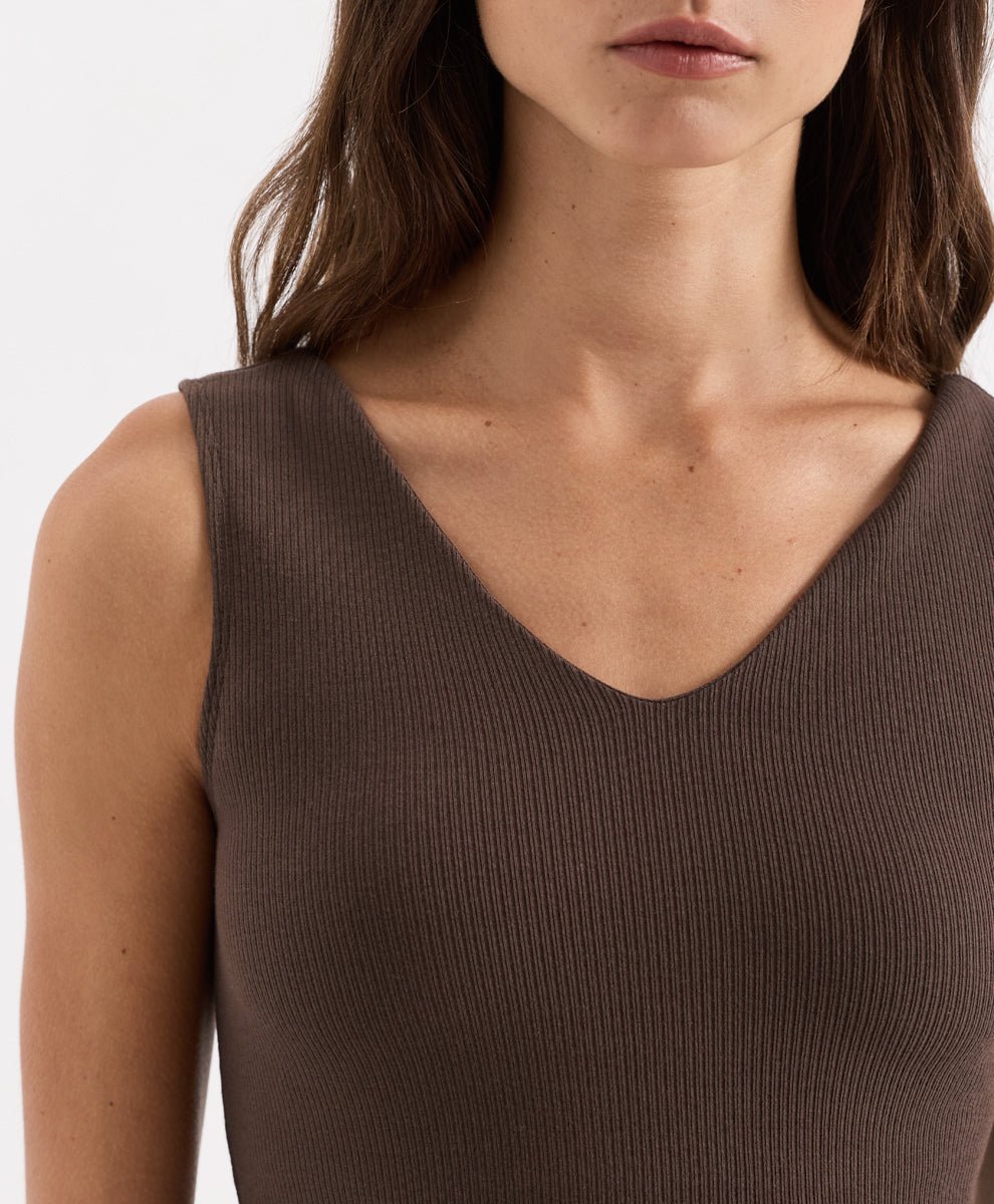 Close-up of a woman wearing a ribbed sleeveless V-neck top in cocoa, showing the texture of the knit fabric.