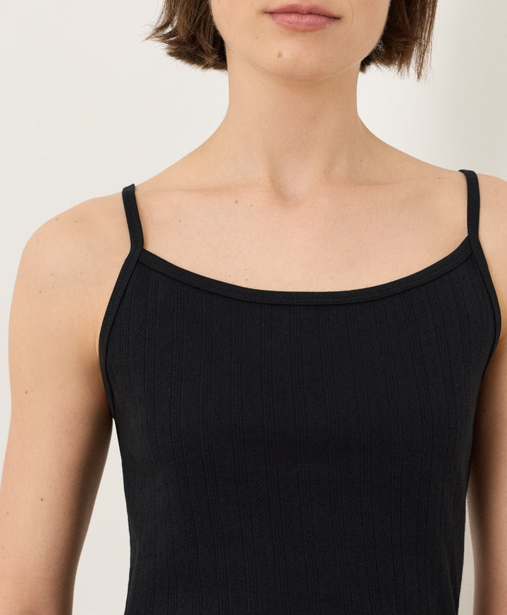 Woman wearing Pact Organic Pointelle Cami in black on a white background