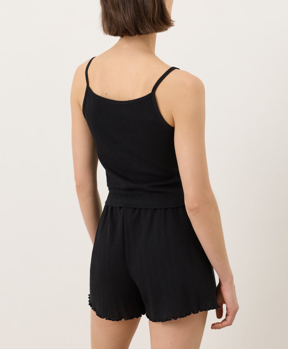 Woman wearing Pact Organic Pointelle Cami and shorts set in black on a white background