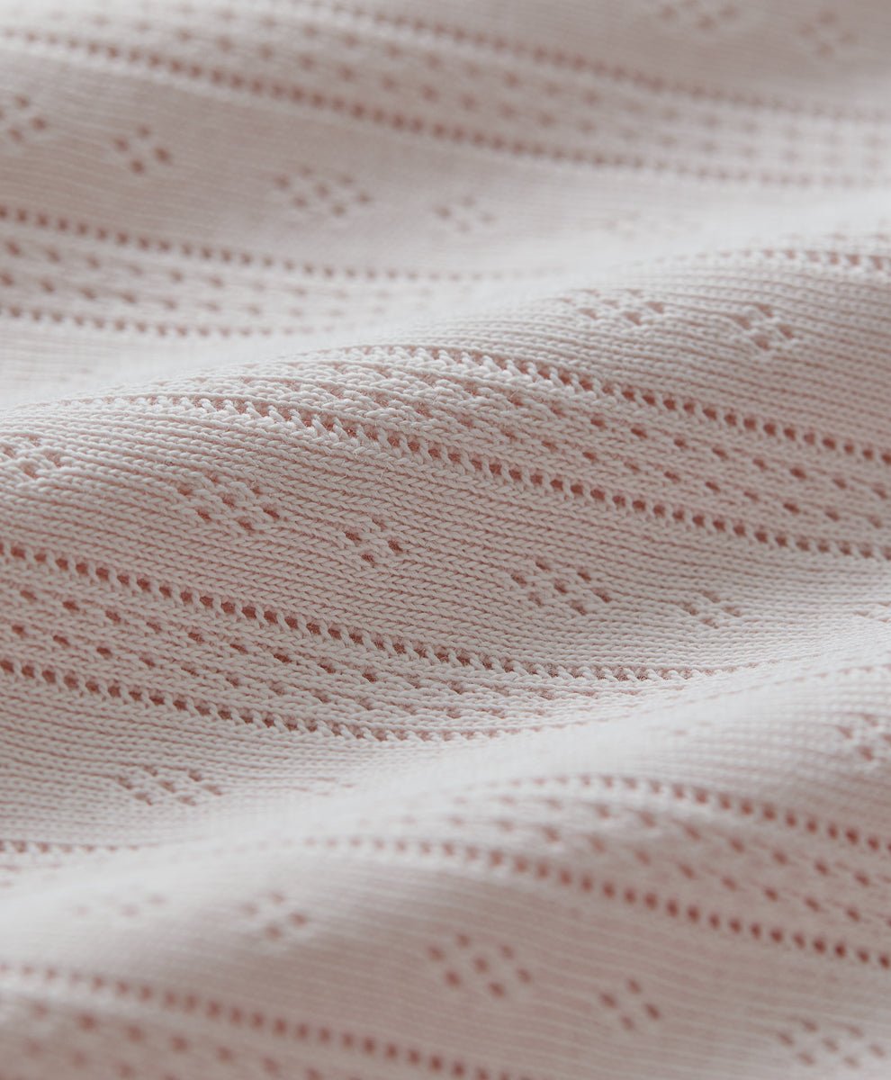 Close-up of pointelle fabric in soft pink.