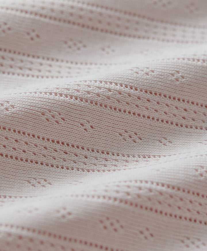 Close-up of pointelle fabric in soft pink.