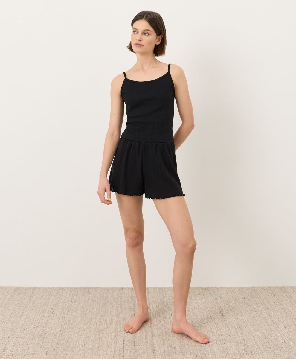 Woman wearing Pact Organic Pointelle Cami and shorts set in black on a white background