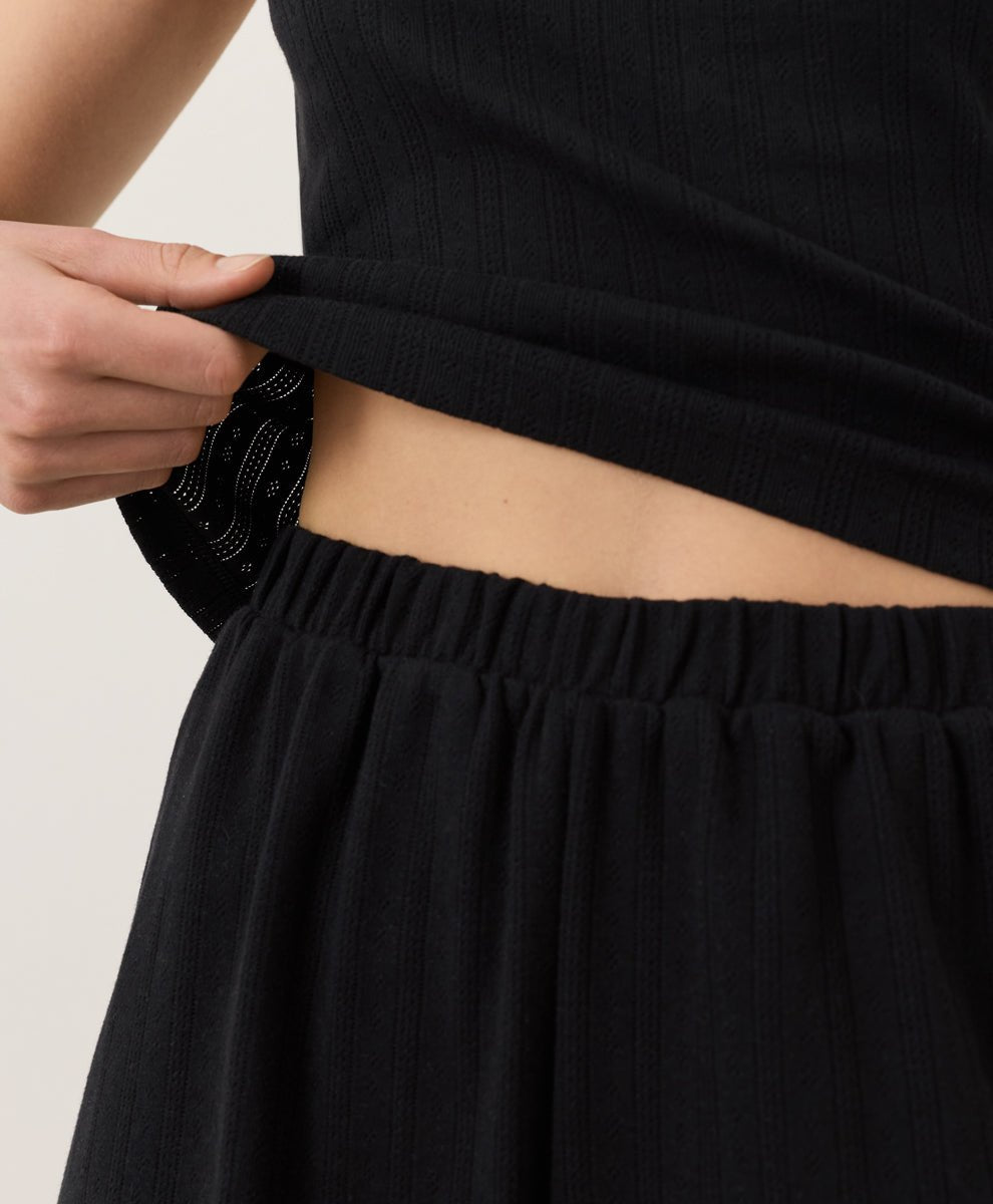 Person wearing black Pact Organic Pointelle Shorts on a plain background