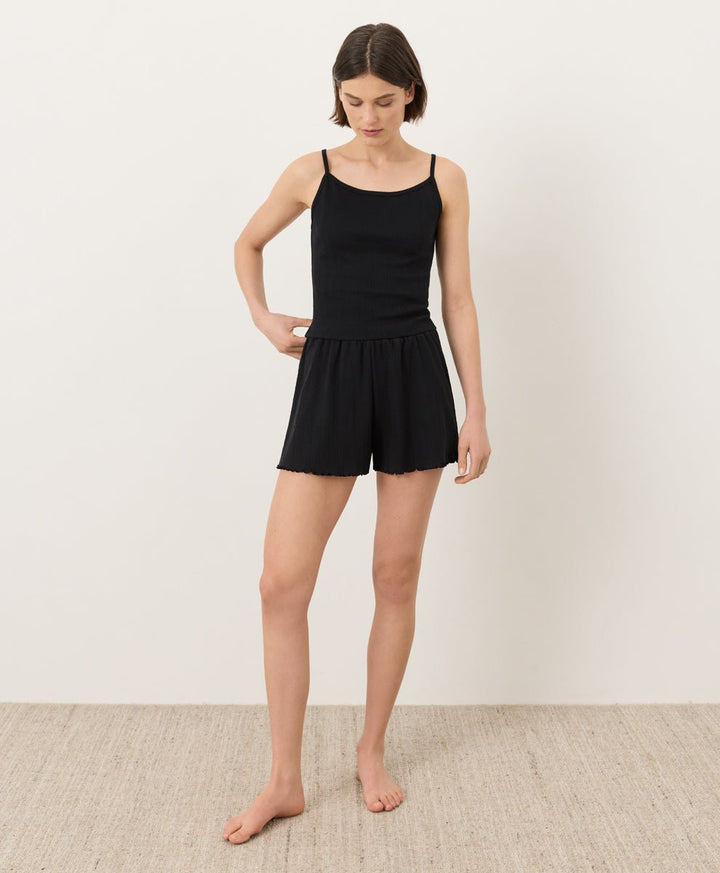 Person wearing black Pact Organic Pointelle Shorts and cami on a plain background
