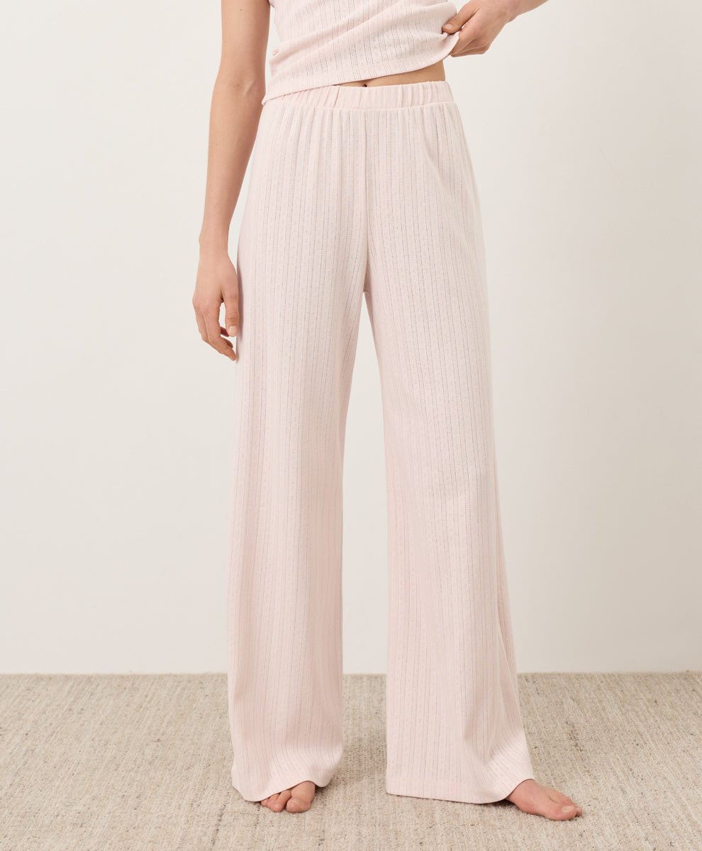 Person wearing Pact's Organic Pointelle Wide Leg Pants in soft pink on a plain background