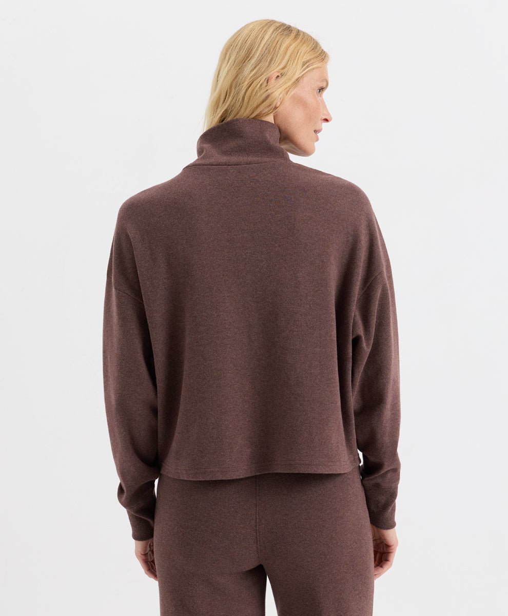 A woman shown from the back wearing a long-sleeve funnel-neck top and matching pants in chestnut heather, set against a plain light gray studio background.
