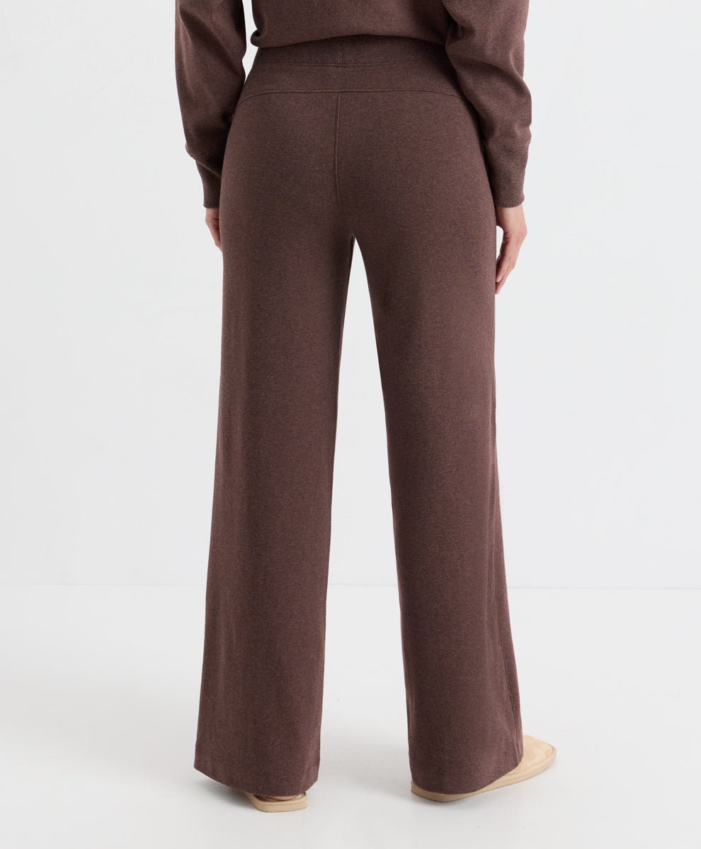 A person shown from the back wearing a matching chestnut heather knit top and wide-leg knit pants, photographed against a clean light gray studio background.