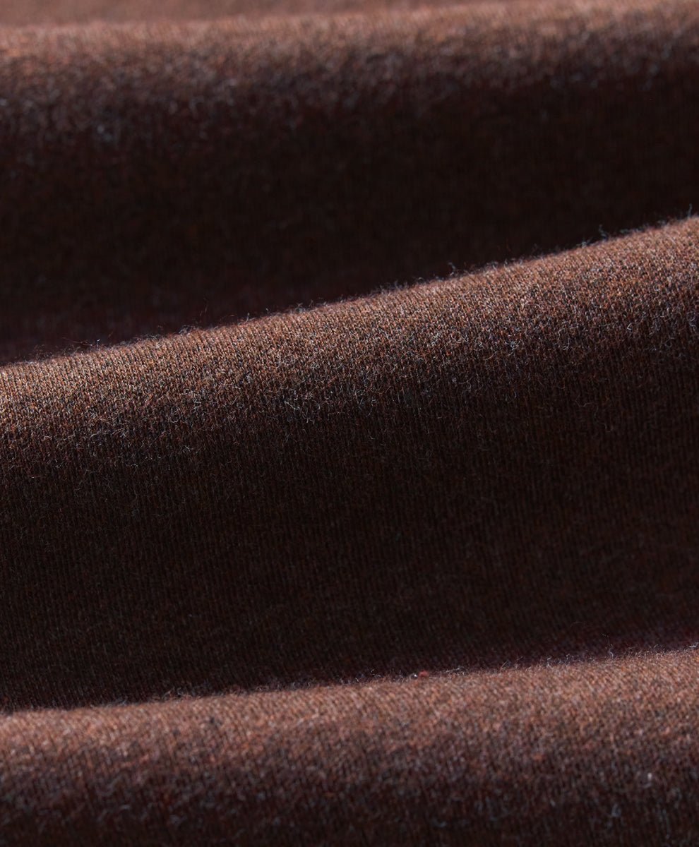 A close-up of draped chestnut heather knit fabric showing its soft texture and fine weave.