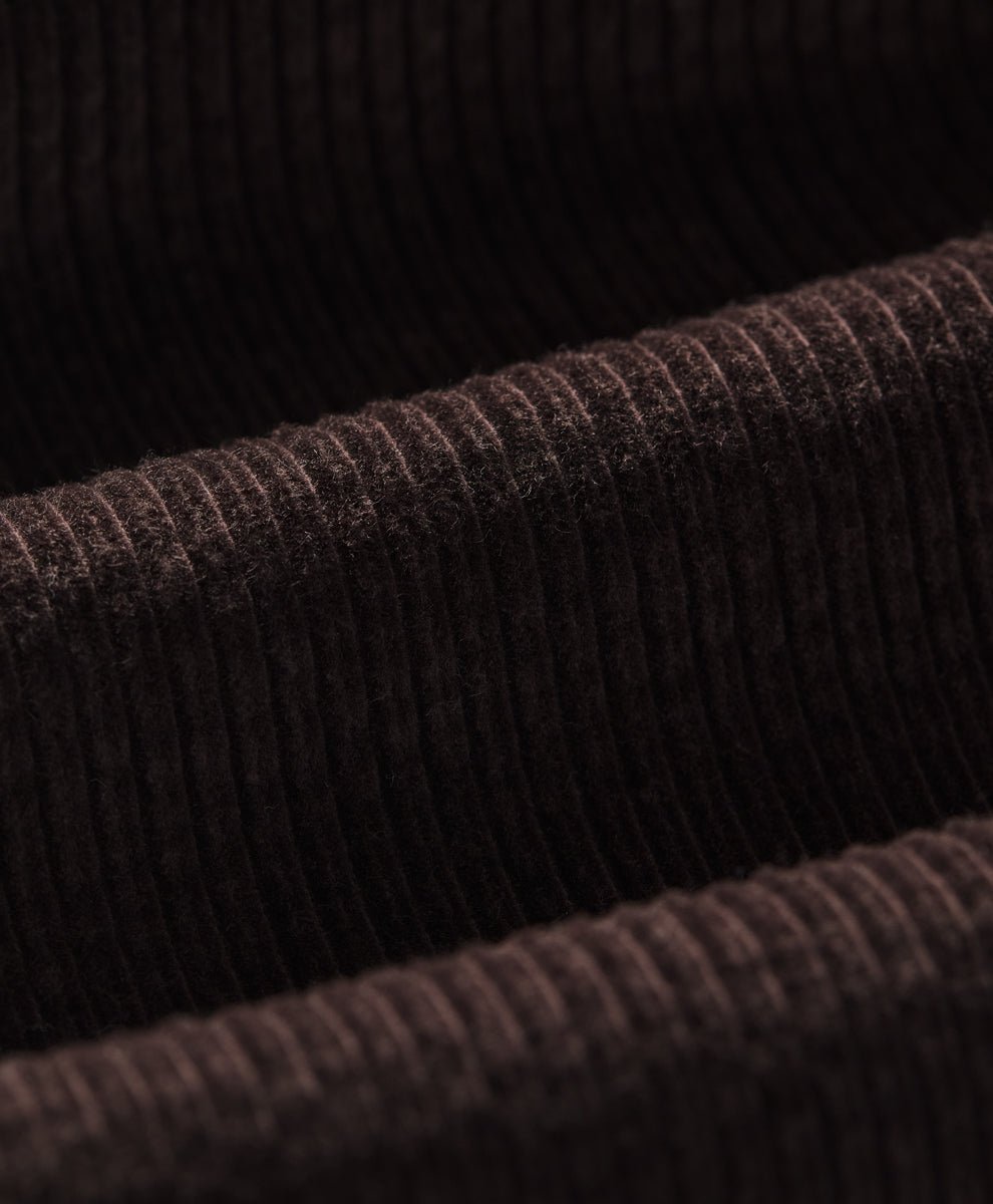 Close-up of a espresso ribbed corduroy fabric texture, showing the detailed vertical ribbing and soft pile.