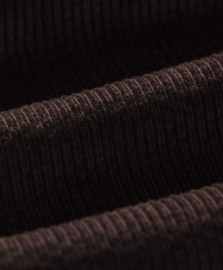 Close-up of a espresso ribbed corduroy fabric texture, showing the detailed vertical ribbing and soft pile.