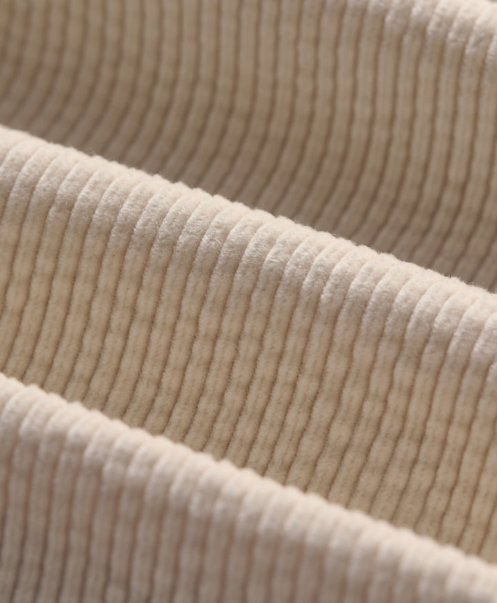 Close-up of corduroy fabric in parchment, showing the texture and folds.